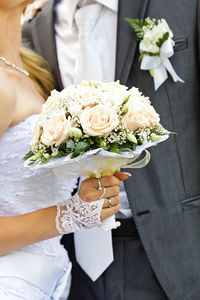 Midsection of woman holding bouquet of roses