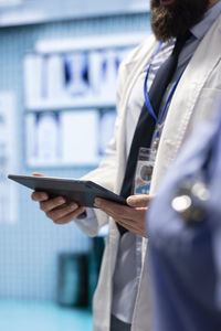 Midsection of man using mobile phone