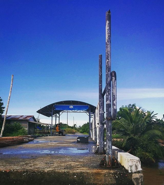 blue, clear sky, built structure, architecture, copy space, low angle view, building exterior, road, tree, day, metal, outdoors, sunlight, transportation, sky, no people, connection, street, metallic, street light