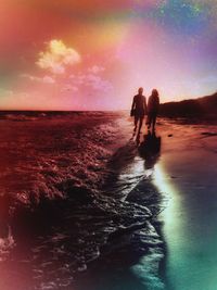 Silhouette people standing on beach against sky during sunset