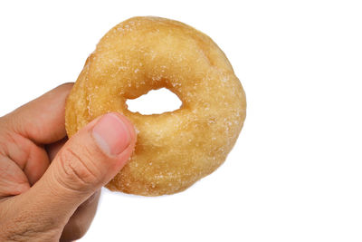 Close-up of hand holding ice cream over white background