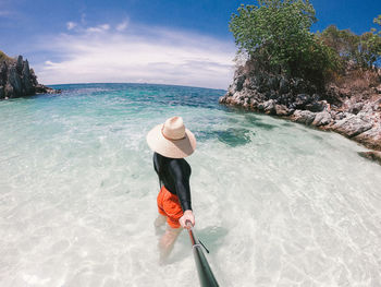 Rear view of person in sea against sky