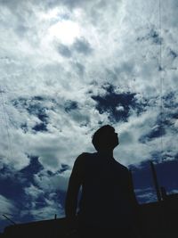 Low angle view of silhouette man standing against sky