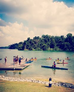 People enjoying at beach against sky