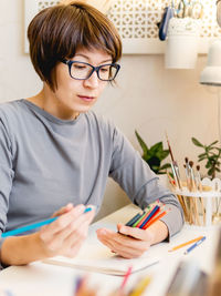 Woman is drawing in notebook. calming hobby, antistress leisure. artist at work. cozy workplace.