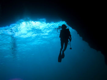 Low angle view of silhouette person swimming in sea