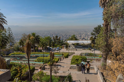 High angle view of people in park amidst buildings against sky