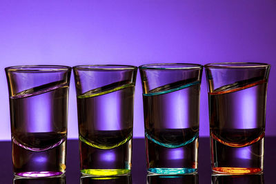Shot glasses arranged side by side on table