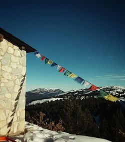 Multi colored flags on mountain against sky