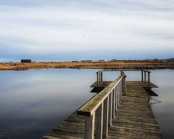 Pier over lake against sky