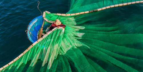 Drone shot of fisherman putting fishing net in sea