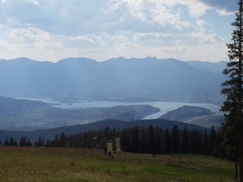 Scenic view of field and mountains against sky