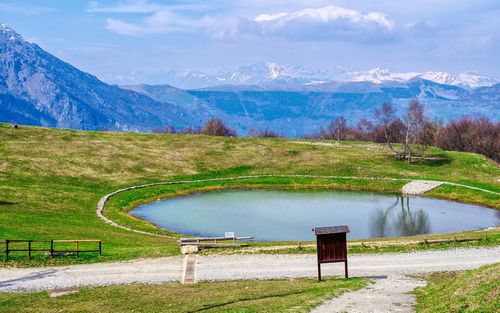 Scenic view of lake by mountains against sky
