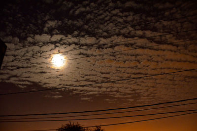 Low angle view of power lines against sky at sunset