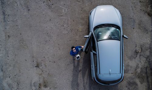 High angle view of man holding remote control by car