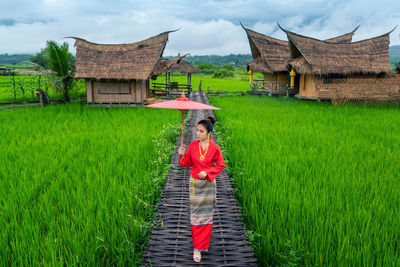 Rear view of woman walking on field