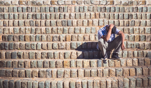 Full length of man sitting on stairs