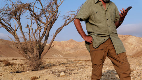 Senior man using mobile phone in the desert 