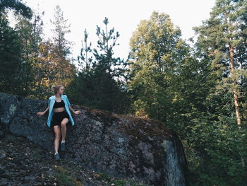 Full length of man standing on rock in forest