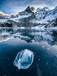 Frozen lake by snowcapped mountain