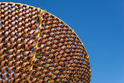 Low angle view of ferris wheel against blue sky