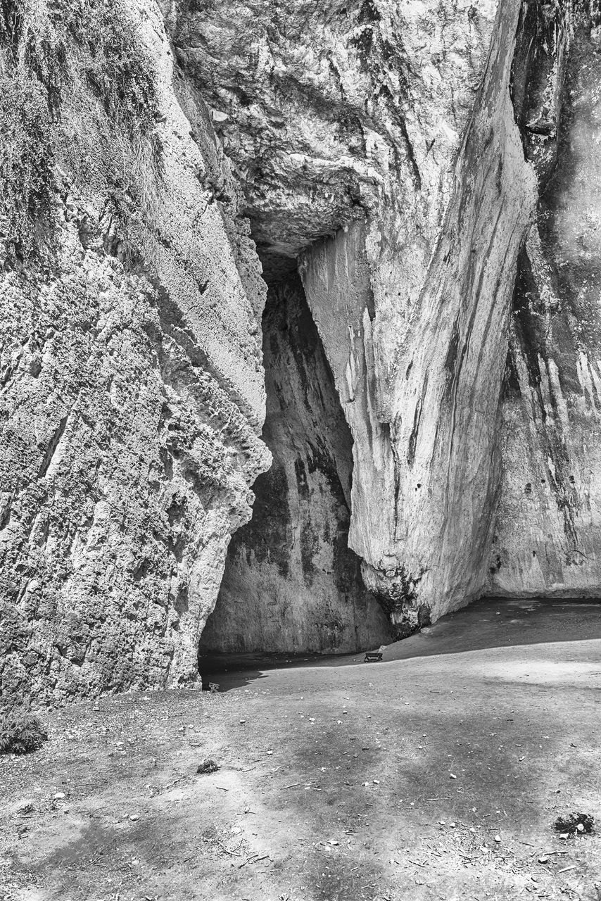 rock, black and white, rock formation, no people, day, monochrome photography, nature, beauty in nature, monochrome, geology, cave, non-urban scene, land, tranquility, physical geography, outdoors, scenics - nature, rough, textured, sunlight, tranquil scene, eroded, formation