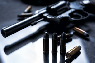 Close-up of bullets and handgun on table