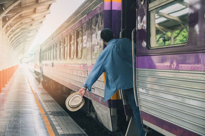 Rear view of man on train at railroad station