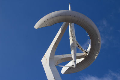 Low angle view of communications tower against blue sky