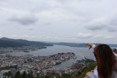 Rear view of woman looking at city buildings against sky