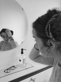 Portrait of woman with reflection on mirror at home