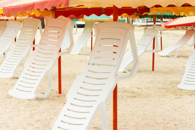 Folded chaise lounges and umbrellas on the sandy beach