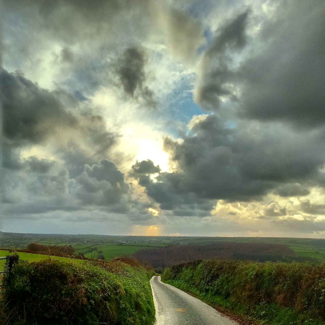 sky, cloud - sky, cloudy, landscape, field, tranquil scene, tranquility, the way forward, scenics, nature, beauty in nature, cloud, grass, rural scene, weather, overcast, road, horizon over land, storm cloud, diminishing perspective