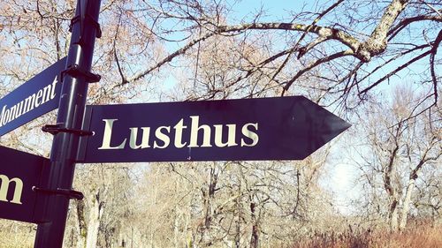 Low angle view of road sign against sky