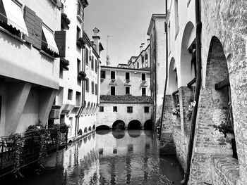 Bridge over canal amidst buildings in city