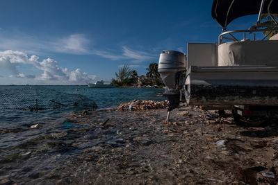 Abandoned boat by sea against sky