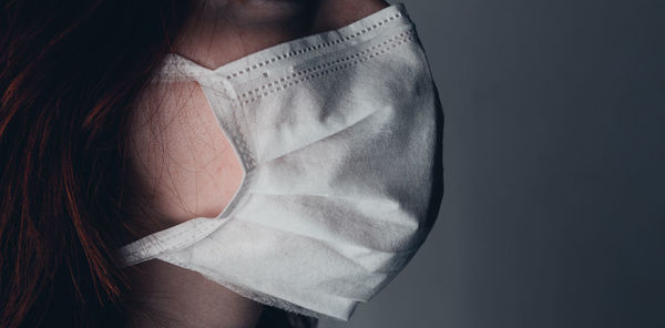 Midsection of woman holding hands against white background