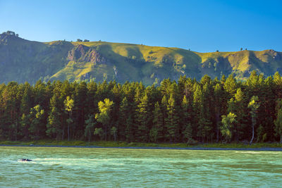 Scenic view of lake and mountains against clear sky