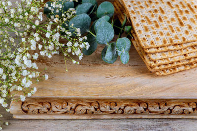 Close-up of flowering plants on wood against wall