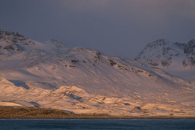 Scenic view of snowcapped mountains against sky at sunset