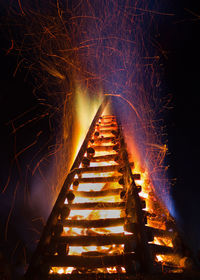 Bonfire with streaming embers in the night sky