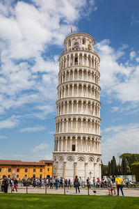 Tourists at the leaning tower of pisa in a beautiful early spring day