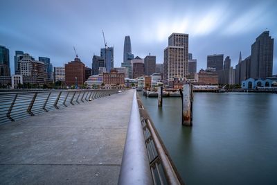 River amidst buildings in city against sky