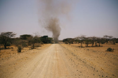 Road amidst desert against clear sky