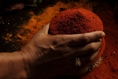 Close-up of hand holding red chili pepper