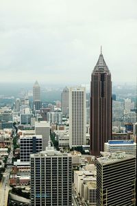 Skyscrapers in city against cloudy sky