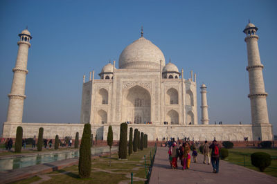 People in front of historical building against clear sky