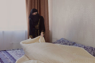 Muslim woman doing housework. refueling and cleaning pastels after sleep.