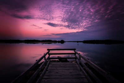 Pier over lake against sky during sunset