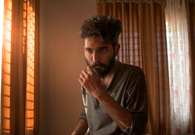 Man sitting in a room with yellow lights.